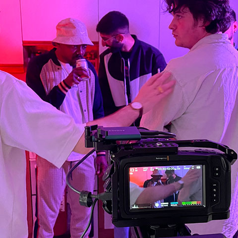 a camera set up in a purple lit room for a photoshoot 