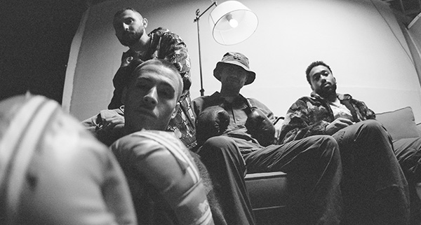 a group of men sitting in Root 73's recording studio